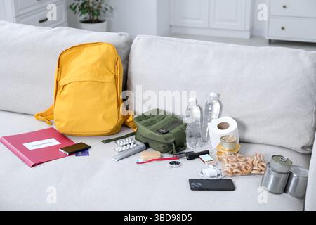 Survival kit. Different emergency supplies on sofa indoors Stock Photo