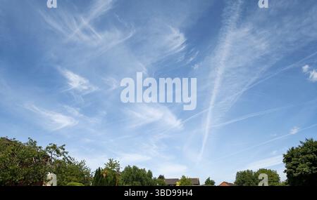 Cirrus clouds and contrails in a blue summer sky in the UK Stock Photo