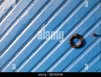 Old blue door with iron handles, at Tollboden warehouse and office buildings in Nordnes, Bergen, Norway Stock Photo