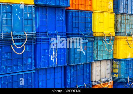 Stack of blue and yellow crates. The crates are stacked on top of each other. The crates are of different sizes and colors Stock Photo