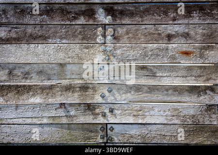 Close-up of weathered wooden boards featuring rusty metal details Stock Photo