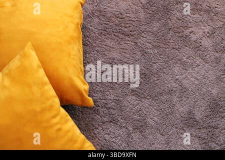 Yellow velvet pillows on soft textured carpet, cozy and minimal interior design background with copy space for mockup or home decor visuals. Stock Photo