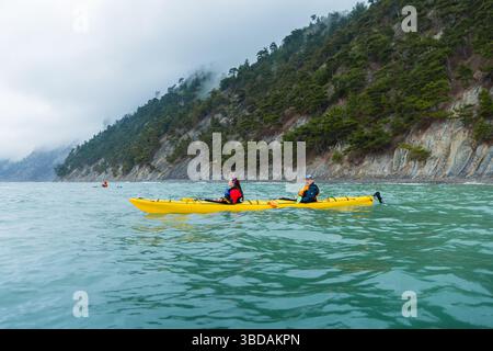 Dubrovnik, Croatia - May 12th 2025. Tandem sea kayaking along the scenic coast in rainy weather Stock Photo