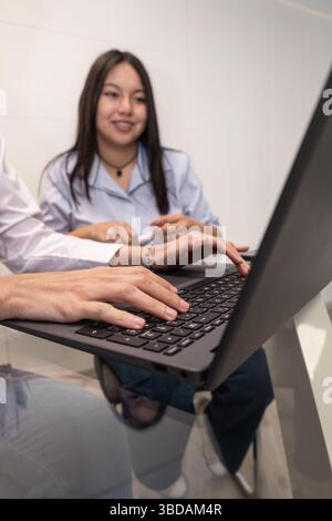 Two young women enjoy a joyful moment while looking at a laptop, capturing a scene of collaboration, friendship, and positive teamwork in a bright set Stock Photo