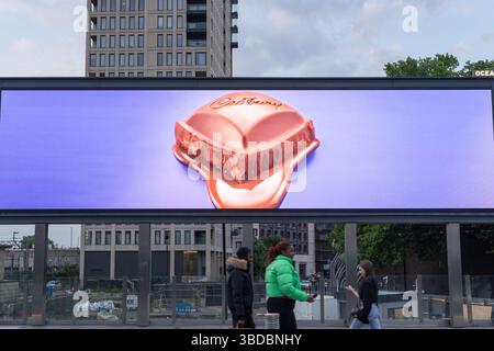 Cadbury showcases a mouth-watering block of melting chocolate on a large outdoor LED billboard,  with its rich texture and appeal, London UK Stock Photo