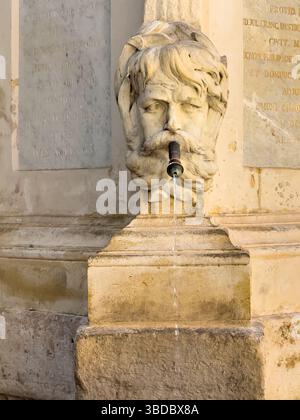Aix-en-Provence, France - July 10, 2024: Fontaine de l'eau benite, holy water, on Place de l'hotel de ville. Detail showing water flowing out of the m Stock Photo