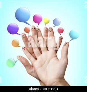 Happy finger smileys with colorful speech bubbles over blue background Stock Photo