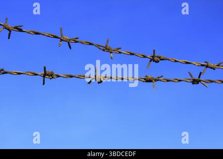 Rusty barbed wire against deep blue sky rusty barbed wire against deep blue sky Stock Photo
