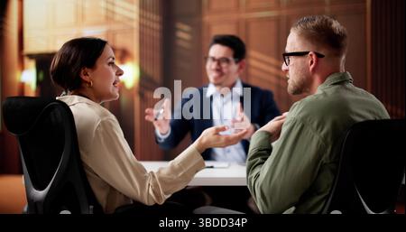 Legal Counselor Mediates Heated Divorce Dispute Between Angry Latino Couple Stock Photo