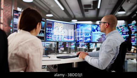 Man And Woman Analyzing Financial Data On Computer Dashboard Together. Stock Photo