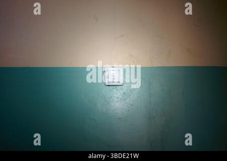 Details of the old wall in the lobby of the building with a light switch in the middle. Stock Photo