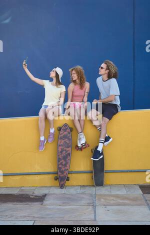 Group of young skaters taking a selfie on a colorful urban background Stock Photo
