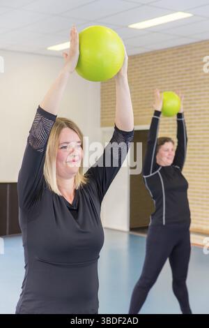 Two middle-aged women with balls at sports lesson Stock Photo