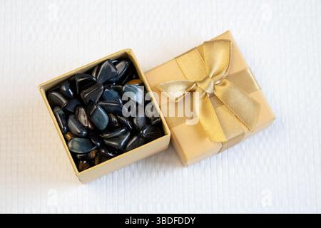 Natural mineral gem stone - Tigers eye or Tiger eye gemstone on white background close-up. Gemstone tiger eye with a golden color contrasted with brow Stock Photo