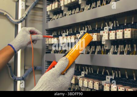 Technicians use multimeter to test or diagnose electrical control devices. Stock Photo