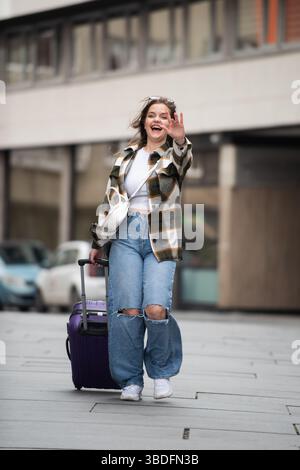 Young Woman Joyfully Walking with Luggage.  Stock Photo