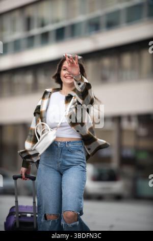 Young Woman Joyfully Walking with Luggage.  Stock Photo