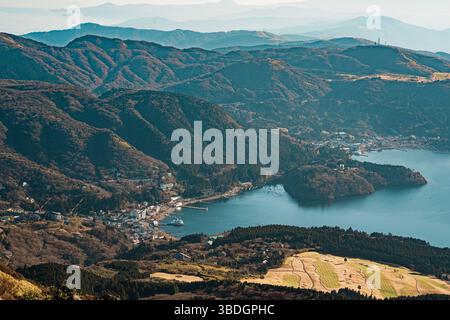 Expansive view from near Hakone Mototsumiya Shrine overlooking Lake Ashi, green valleys, distant ridges, and peaceful rural landscapes. Stock Photo