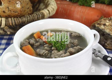 Liver spaetzle soup with vegetables and parsley in a soup bowl Stock Photo