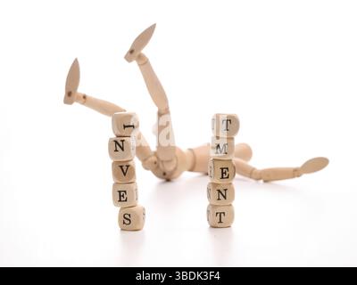 Financial risk concept with a fallen wooden puppet and dices with the word investment Stock Photo