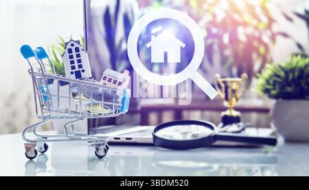 Miniature Houses in Shopping Cart with House Icon Symbolizing Property Selection, Digital Market Research, and Investment Success Stock Photo