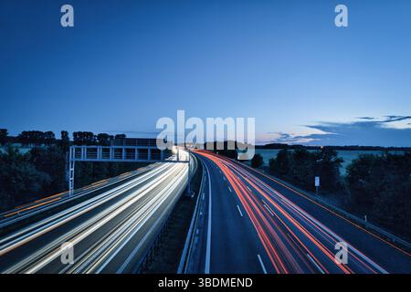 German Autobahn at night Highway Street Asphalt Speed ​​Traffic Light Trails Motorway Long Exposure Car Sunset Vacation Stock Photo