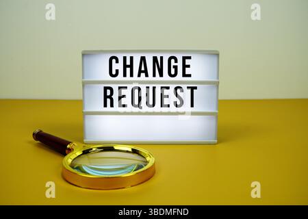 Change Request text on LED lightbox with magnifying glass on yellow background Stock Photo