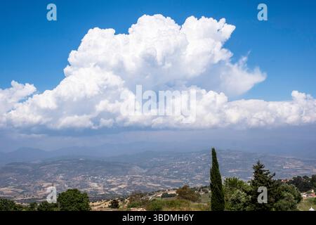 White fluffy Cumulonimbus clouds over the Troodos Mountains range, Republic of  Cyprus. Stock Photo