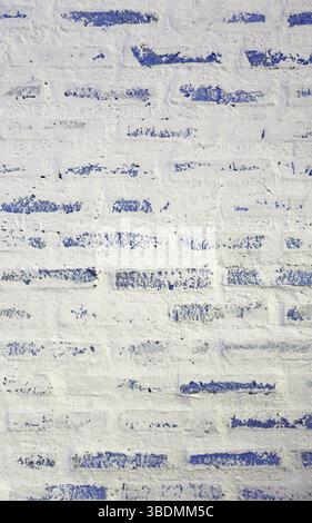 Front View of Grunge Painted White and Blue Brick Wall Stock Photo