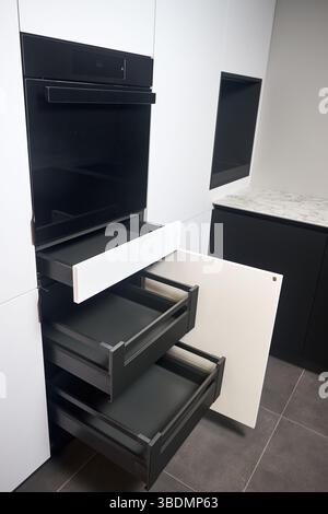 Interior of kitchen with lots of built-in upper and lower cabinets, oven, drawers and shelves. Cabinet Door Drawers with Soft Quiet Closer Damper Buff Stock Photo