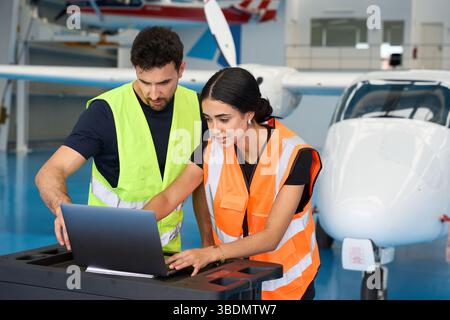 Aircraft mechanics using laptop for maintenance in hangar Stock Photo