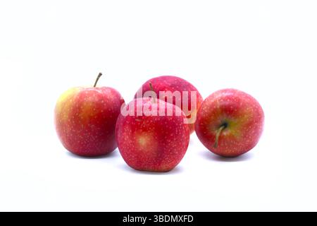 Group of fresh red apples on an elegant glass cake stand with two apples beside it, isolated on a white background. Ideal for healthy food concepts. Stock Photo