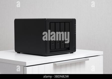NAS server. Network storage. Device for backing up important information on a white bedside table. For home or office. Stock Photo