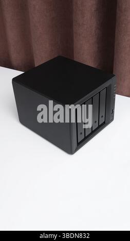 NAS server. Network storage. Device for backing up data on a white table in the room. Place for text. Stock Photo