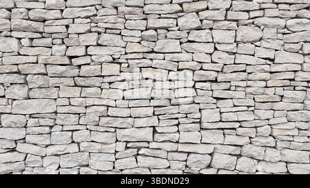 A wall made of natural white stone. Stock Photo