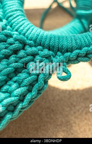 Stylish knitted bag made of green cotton rope. Macrame technique. Individual order. Craft product. Stylish knitting. Women s accessory. Crochet bag. Stock Photo