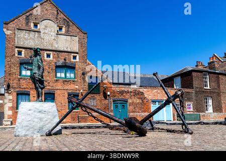 The anchors stand on Purfleet Quay next to the statue of Captain George Vancouver under the blue West Norfolk sky, taken 20th May 2025. Stock Photo