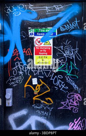 Graffiti on a fire exit door on a city street, UK Stock Photo