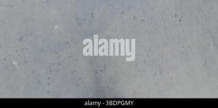 Close-up of a gray concrete surface featuring various small spots and textures Stock Photo