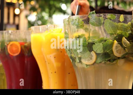 Refreshing drinks. Mojitos and lemonades in plastic containers at the food court. Assortment of summer drinks. Drinks on tap. Bar with drinks Stock Photo