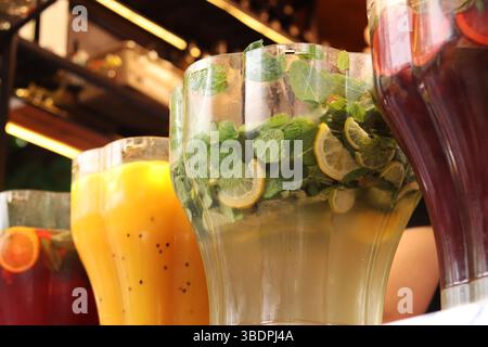 Refreshing drinks. Mojitos and lemonades in plastic containers at the food court. Assortment of summer drinks. Drinks on tap. Bar with drinks Stock Photo