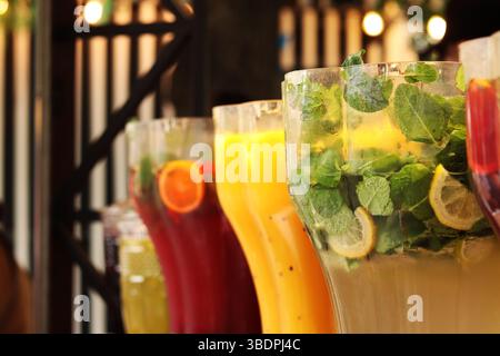 Refreshing drinks. Mojitos and lemonades in plastic containers at the food court. Assortment of summer drinks. Drinks on tap. Bar with drinks Stock Photo