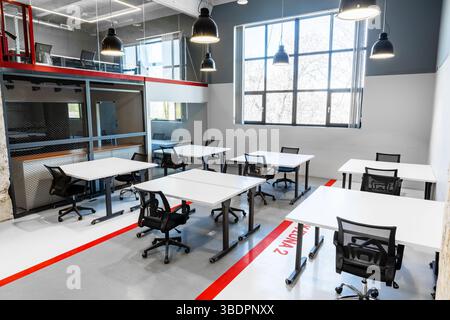 Modern workspace with multiple desks and bright natural light in a collaborative office environment Stock Photo