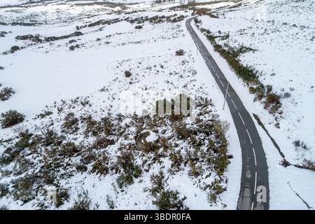 aerial drone view of winding road through snowy winter landscape Stock Photo