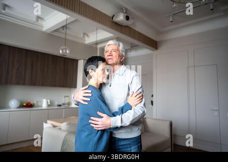 Elderly sad man hug comforting wife. Old couple support, emotional care support, love health issues Stock Photo