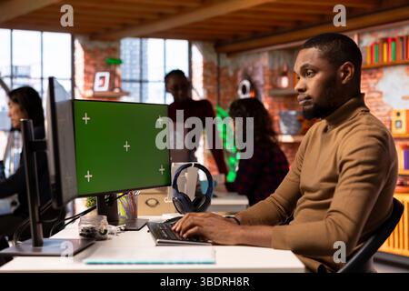 Startup entrepreneur using green screen PC to do research, looking to grow value of company. African american venture business manager using mockup computer, building innovative growth strategy Stock Photo