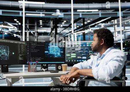 Engineer with paraplegia in inclusive data center using artificial intelligence visualization tools to identify bugs. Server hub worker with disability in wheelchair using AI insights to detect errors Stock Photo