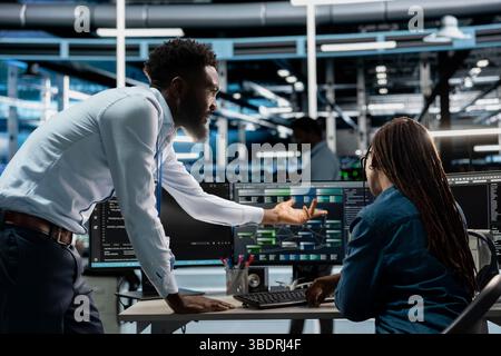 Data center system administrators setting up machine learning systems handling information. IT professionals in office training neural networks node trees to improve server farm operations Stock Photo