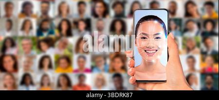 A hand holds a smartphone displaying a facial recognition scan of a person Stock Photo
