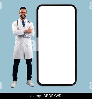 Doctor pointing at big white empty smartphone screen, mock-up Stock Photo